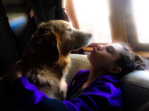 A picture of Kyra Zagorsky with her Golden Retriever.